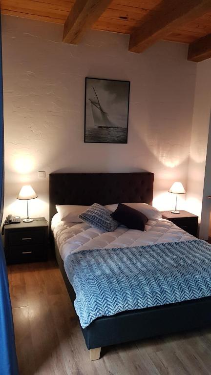 una camera con un grande letto con due lampade di Auberge du Vernay a Charette