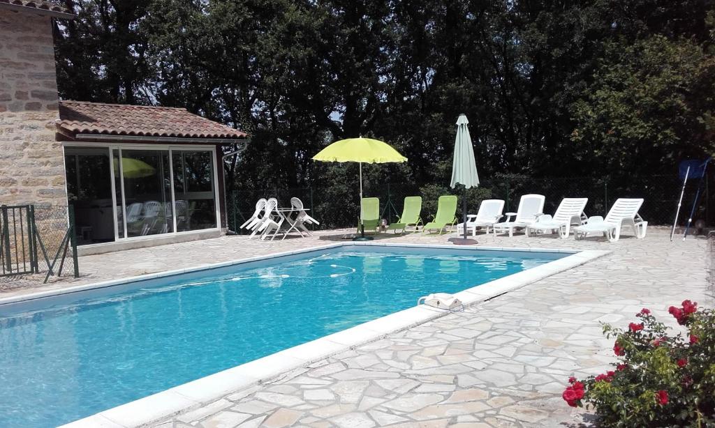 a swimming pool with chairs and a yellow umbrella at saint trome in Espinas