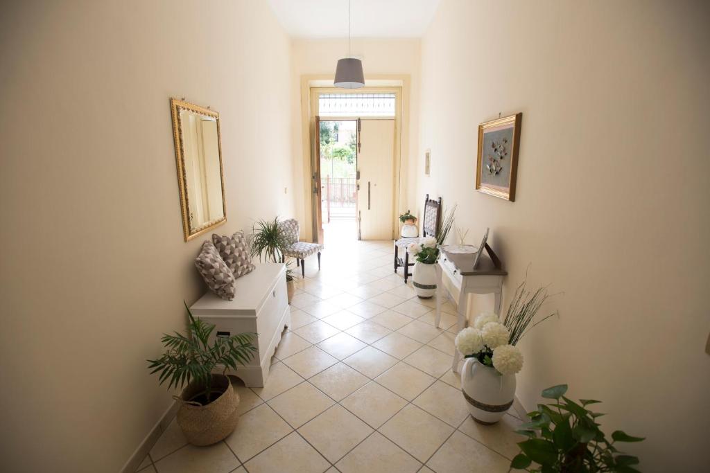 un soggiorno con piante in vaso e un corridoio di Villa Giusy a Marina di Camerota