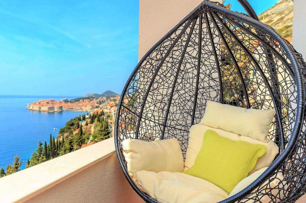 uma cesta de pendurar cadeiras com vista para o oceano em Dubrovnik Colors - Old Town View Apartment No3 em Dubrovnik