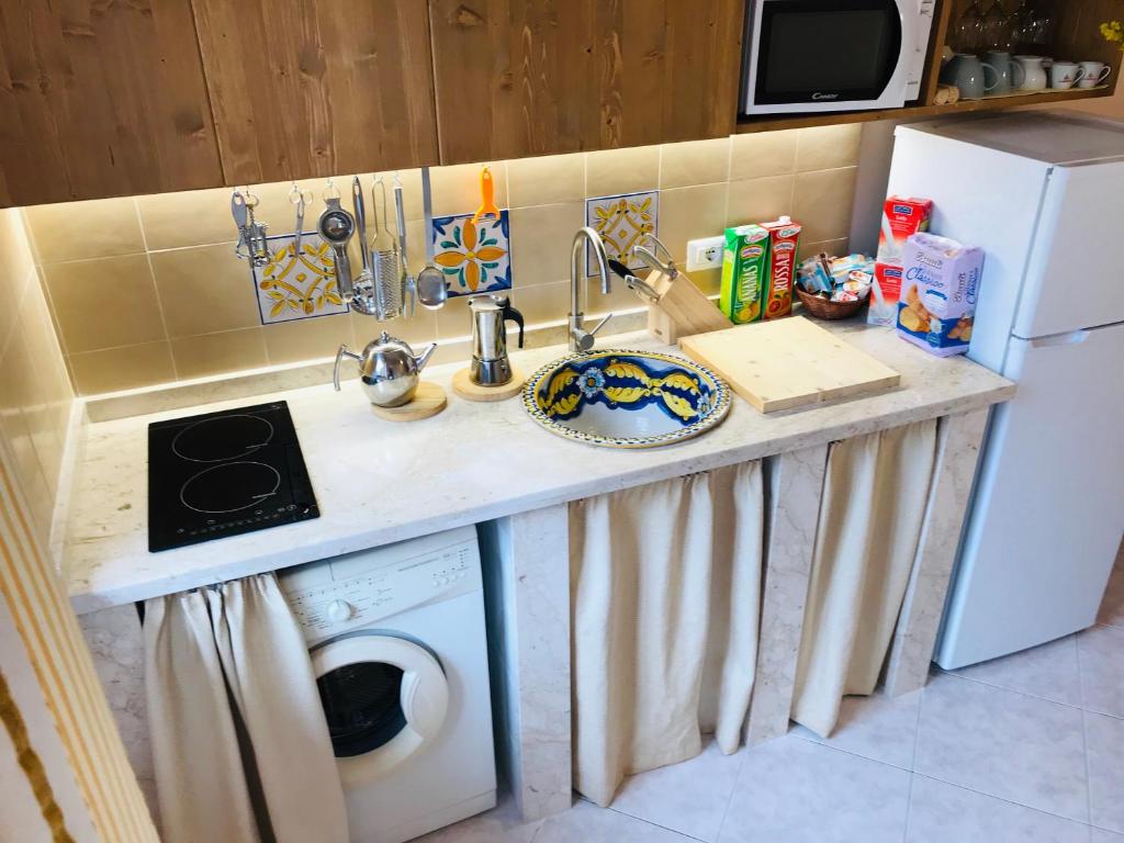 a kitchen counter with a sink and a washing machine at Adriana casa vacanze mare Etna Sicilia in Acireale