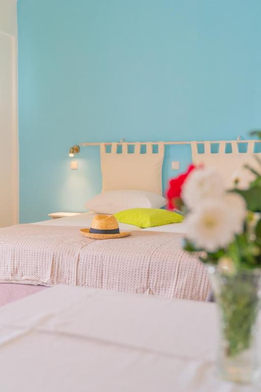 a bed with a hat and a vase of flowers at Kassiani Studios in Plakias