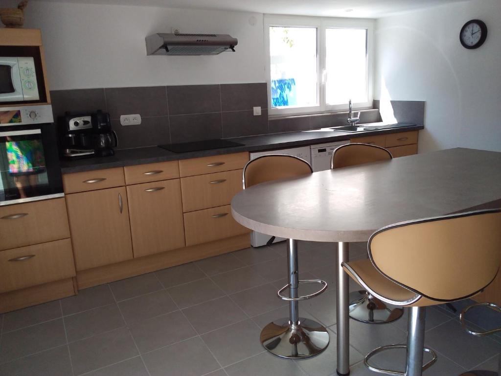 una cocina con mesa y algunas sillas. en Appartement T2, en Moliets-et-Maa