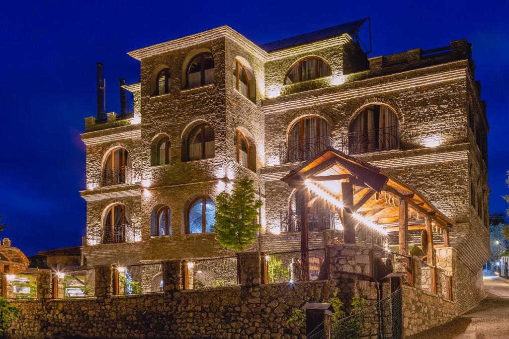 un vieux bâtiment avec des lumières allumées la nuit dans l'établissement Hotel Restaurant Emblema, à Petrelë