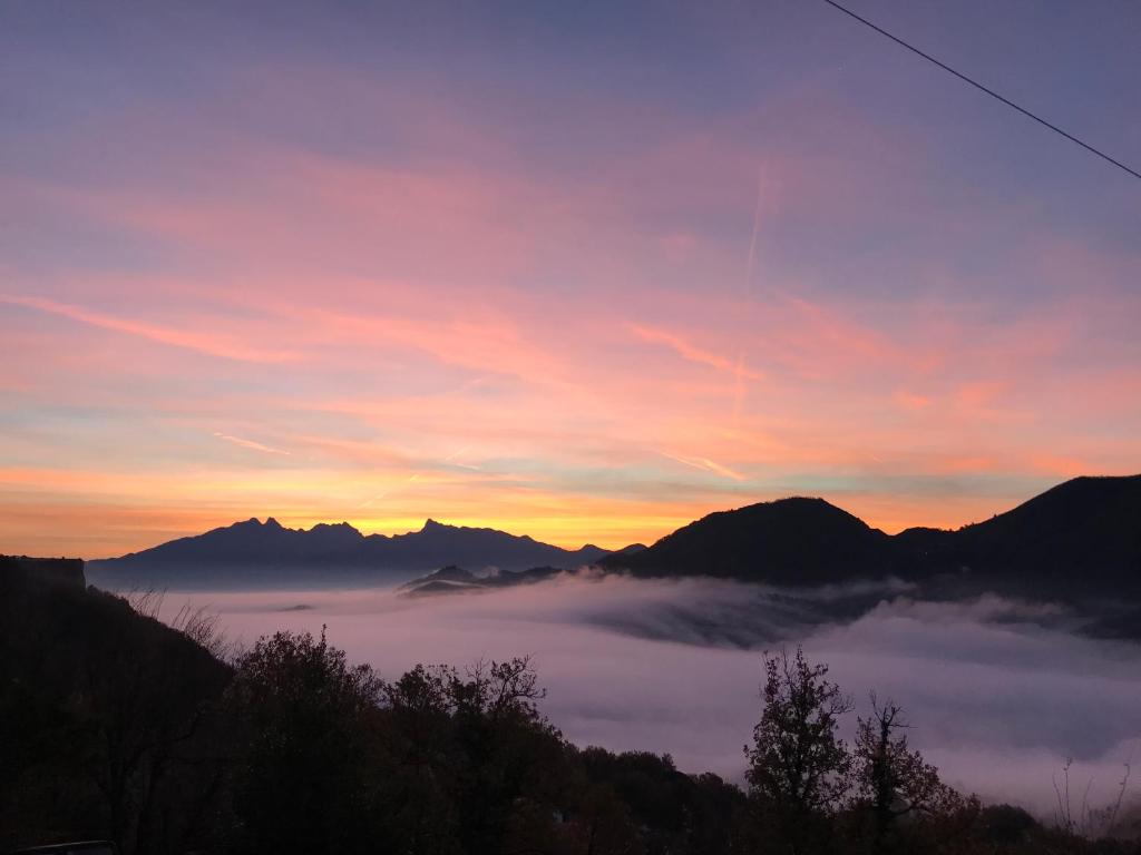 - une vue sur une chaîne de montagnes couverte de brouillard et le coucher du soleil dans l'établissement Hotel Mirador, à Aulla