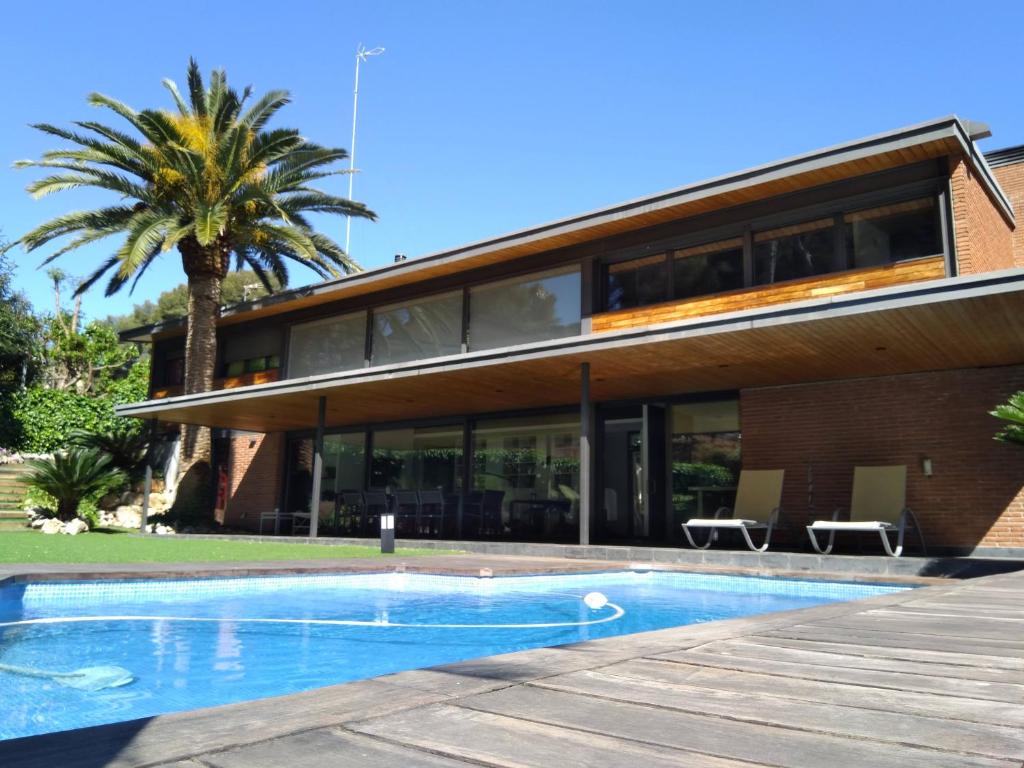 VILLA DEL BOSQUE في كاستيلديفِيلس: منزل أمامه مسبح