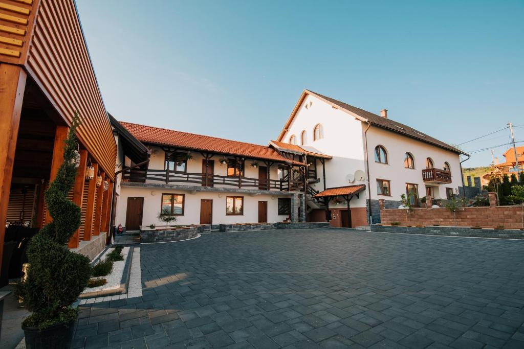 a courtyard of a building with a stone driveway at Pensiunea Biz Panzió in Corund