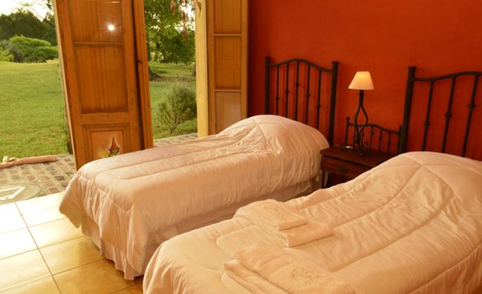 2 camas en una habitación con ventana en Alquimia Posada en Guichón