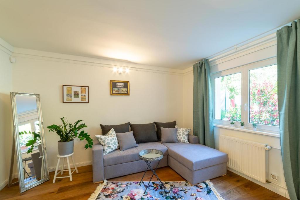 ein Wohnzimmer mit einem Sofa und einem Fenster in der Unterkunft Bürgerpark Apartments in Berlin