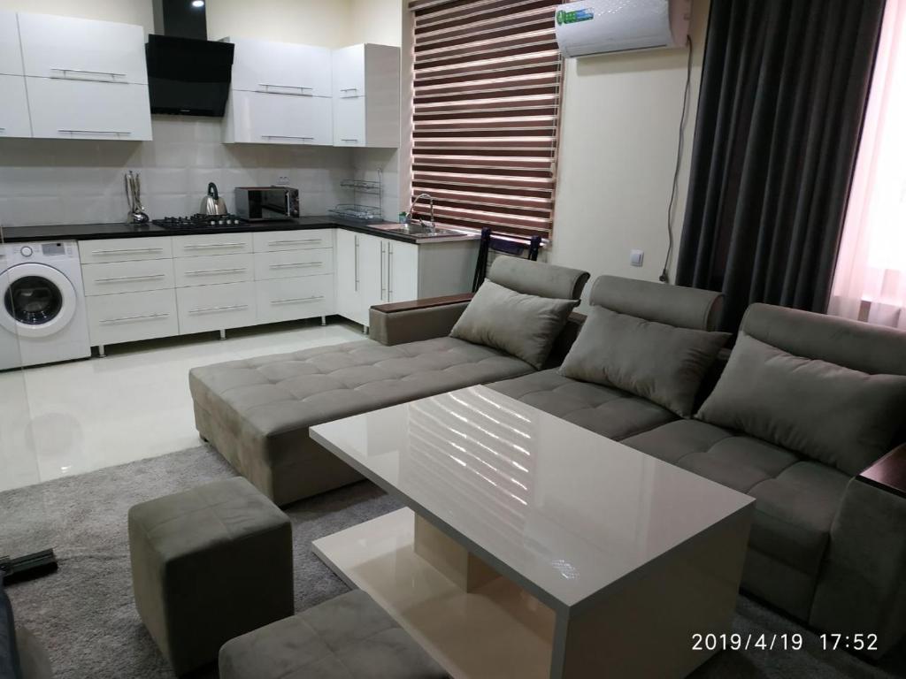 sala de estar con sofá y mesa en Аппартаменты Rohat, en Samarkand