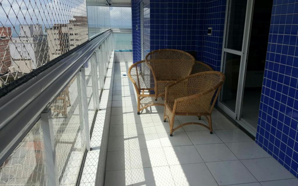 balcón con 2 sillas y vistas a la ciudad en Lindo apartamento bairro Aviação, en Praia Grande