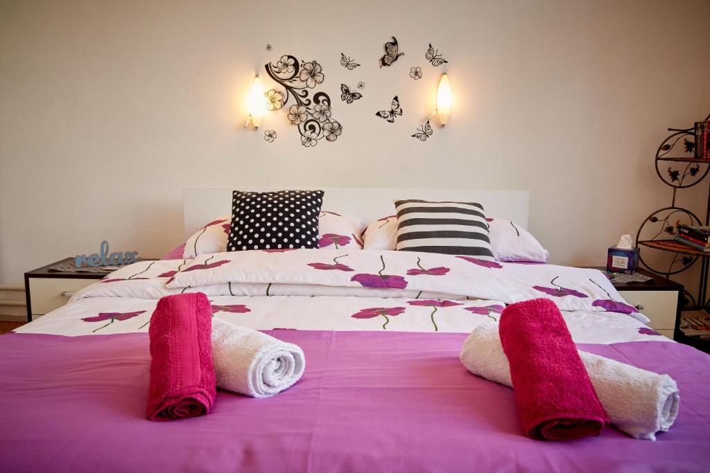 a bedroom with a bed with pink towels on it at Central Tuzla apt - free parking in Tuzla