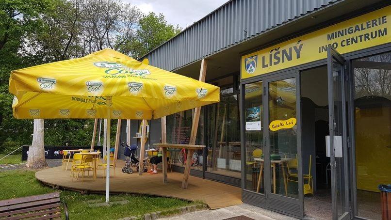 einem großen gelben Regenschirm vor einem Restaurant in der Unterkunft Galerka Líšný in Líšný