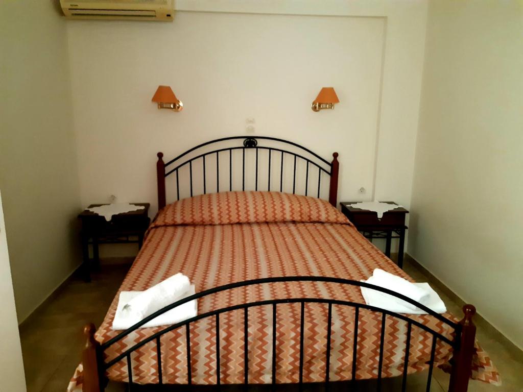 a bedroom with a bed with an orange comforter at Vrokastro Apartments in Istro