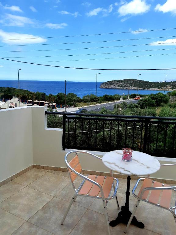 a table and chairs on a balcony with a view of the ocean at Vrokastro Apartments in Istro