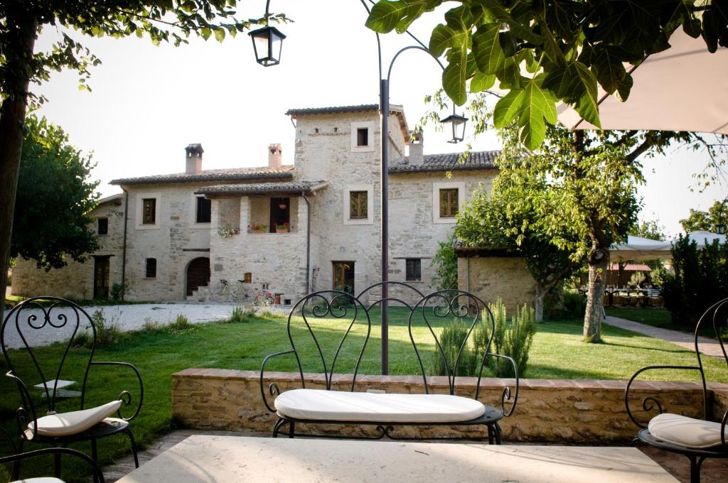 um pátio exterior com cadeiras e um edifício em Locanda Rovicciano em Castel Ritaldi