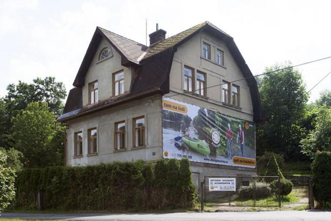 uma casa com um grande mural ao lado em Turistická ubytovna U Tlusťocha em Malá Skála
