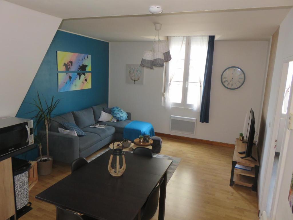 ein Wohnzimmer mit einem Sofa und einem Tisch in der Unterkunft Grand appartement chaleureux in Thouars