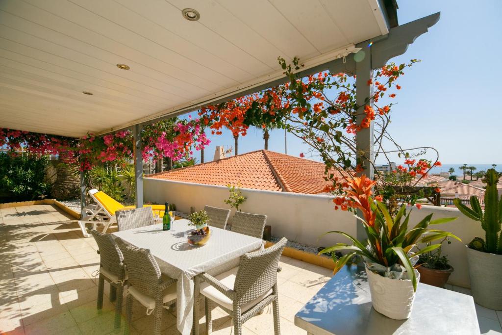 una mesa y sillas en un patio con flores en Bungalow Claire, en Callao Salvaje