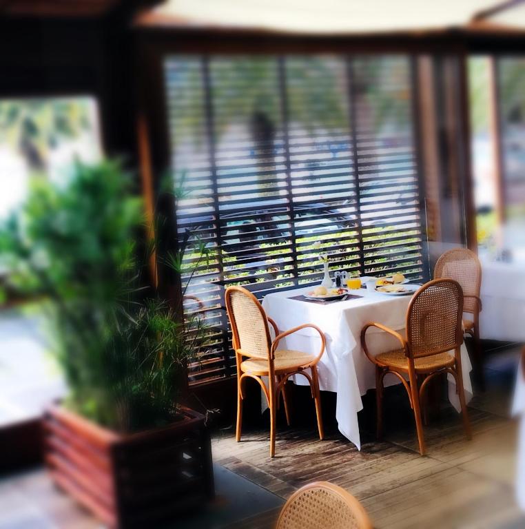 a table with chairs and a white table cloth on a balcony at Hotel Della Baia in Portovenere