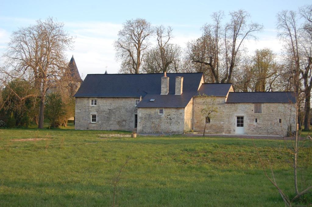 une ancienne maison en pierre dans un champ d'herbe dans l'établissement Gite du chateau, à Marigny