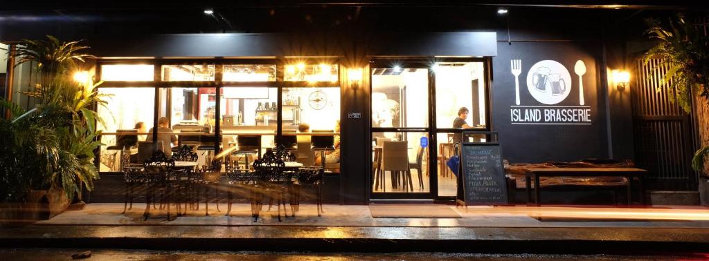 a restaurant with tables and chairs outside at night at Island Brasserie Hostel in Coron