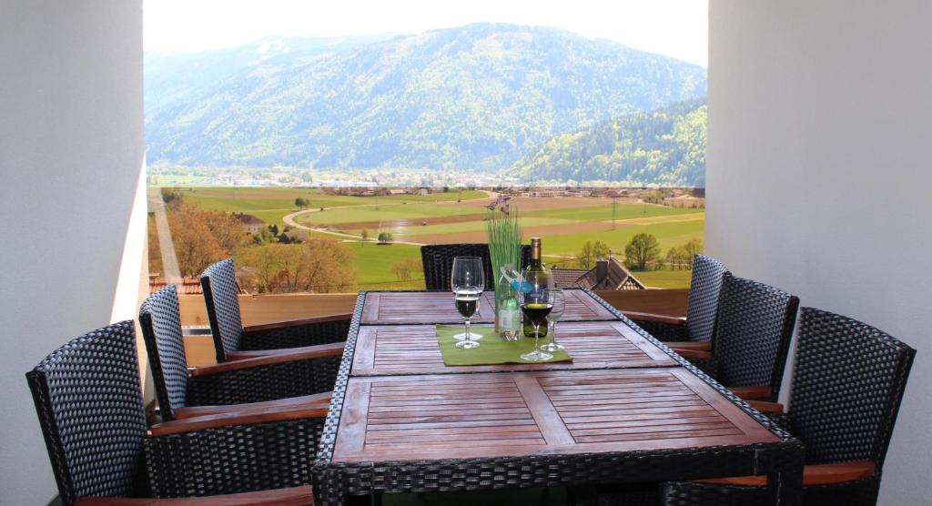 a table with wine glasses and a view of a mountain at Appartements Dürnle in Mühldorf