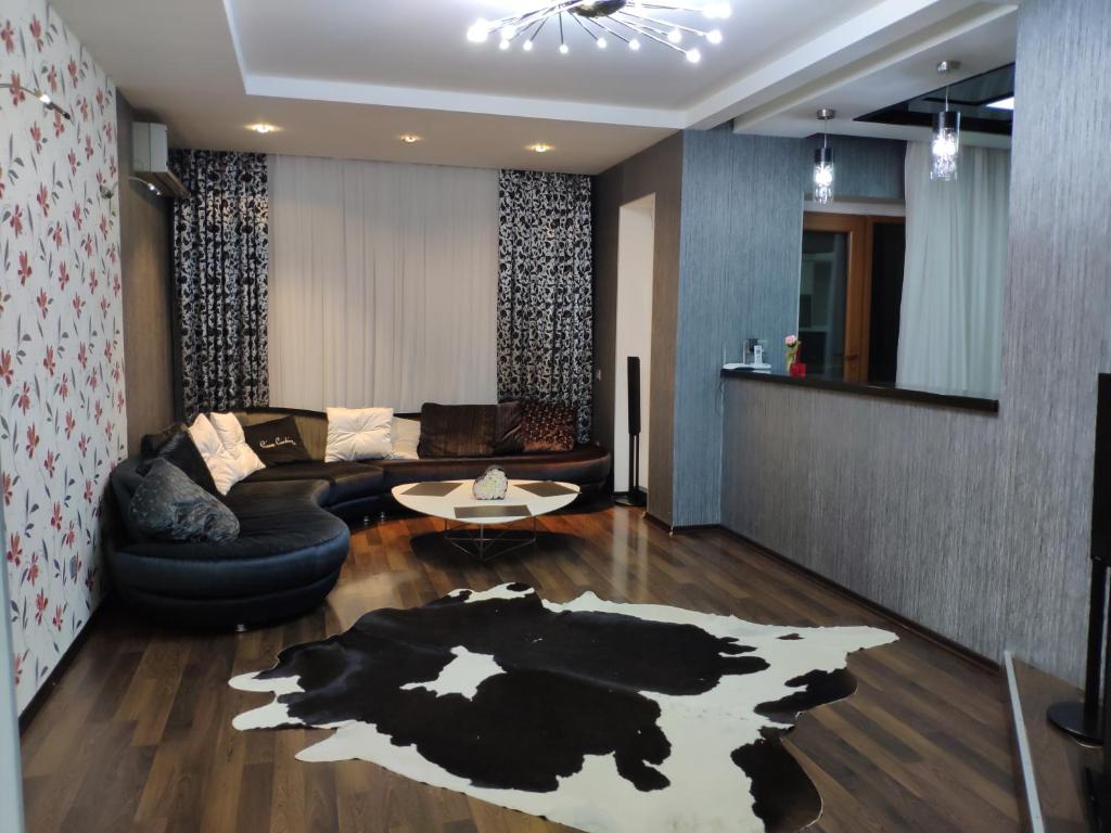 a living room with a couch and a cow rug at Nizami Apartment in Baku
