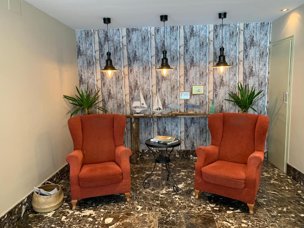 two chairs and a table in a waiting room at Hotel Arcea Villaviciosa in Villaviciosa