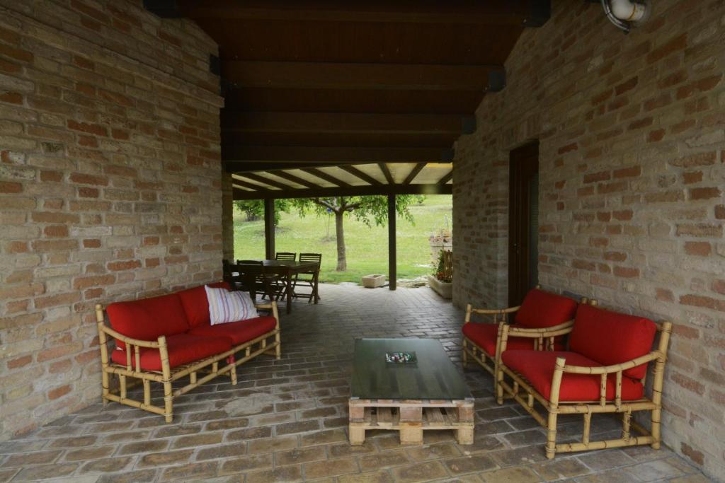patio z czerwonymi krzesłami i stołem na murze. w obiekcie casa Nenella w mieście Corridonia