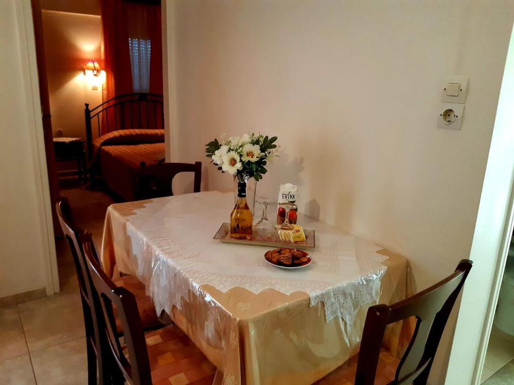 a table with a vase of flowers and a plate of food at Vrokastro Apartments in Istro