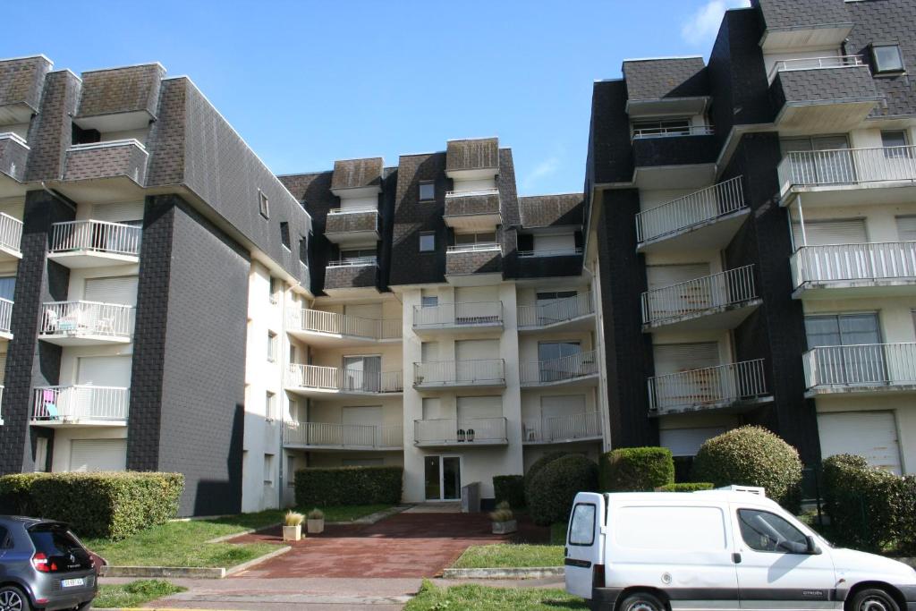 an apartment building with a white van parked in front at calypso 2 in Berck-sur-Mer