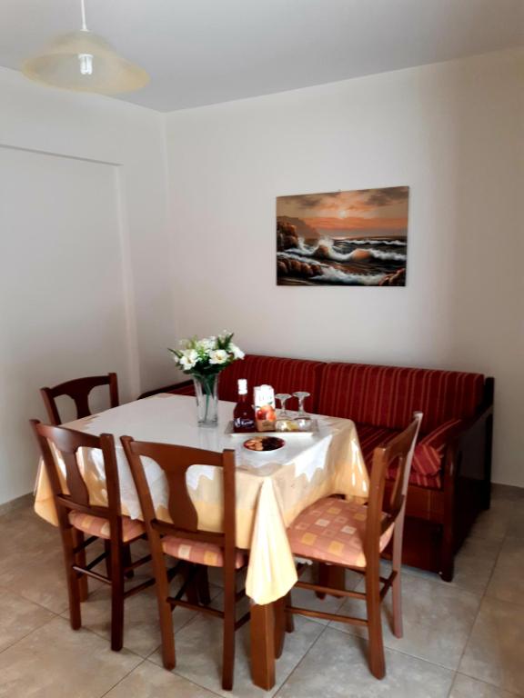a dining room with a table with chairs and a table and a painting at Vrokastro Apartments in Istro