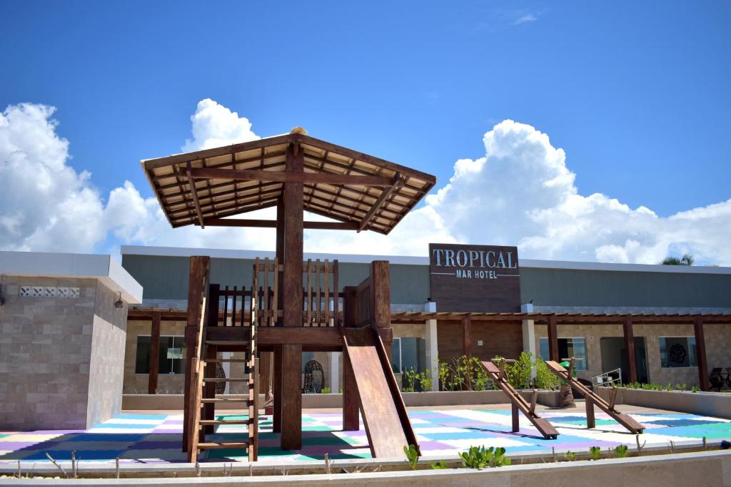 a large wooden chair statue in front of a building at Tropical Mar Hotel in Aracaju