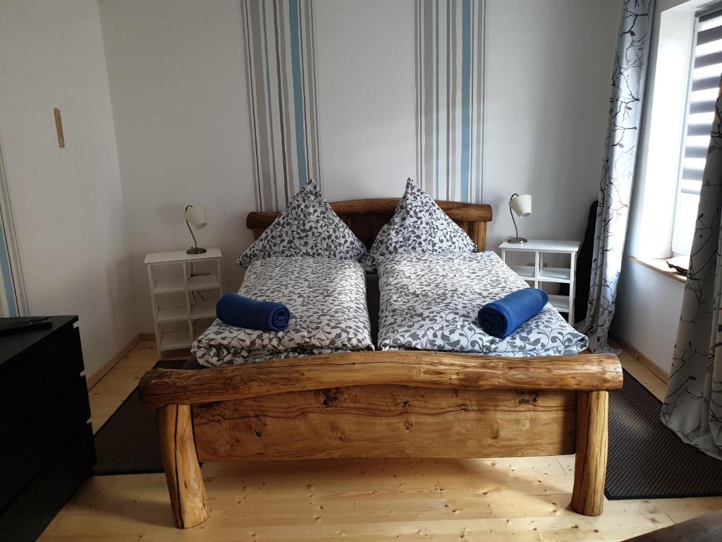 a bedroom with a wooden bed with pillows at "kleine Boddenburg" in Barth