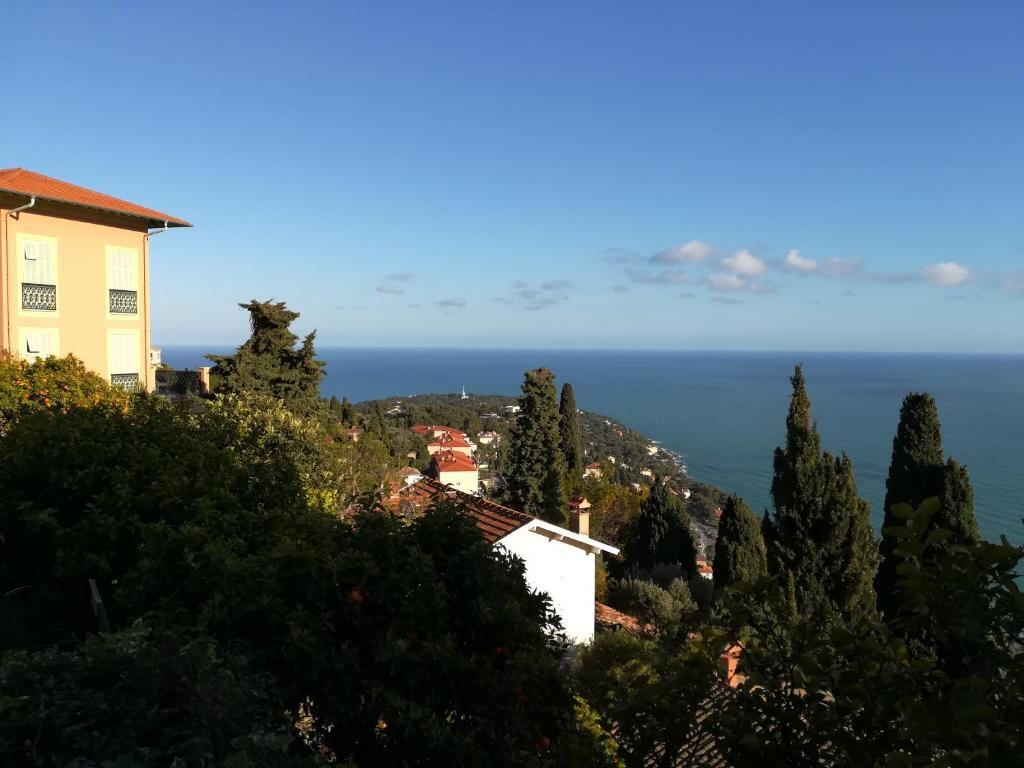 una casa en una colina con el océano en el fondo en Monaco's Cottage & Spa en Roquebrune-Cap-Martin