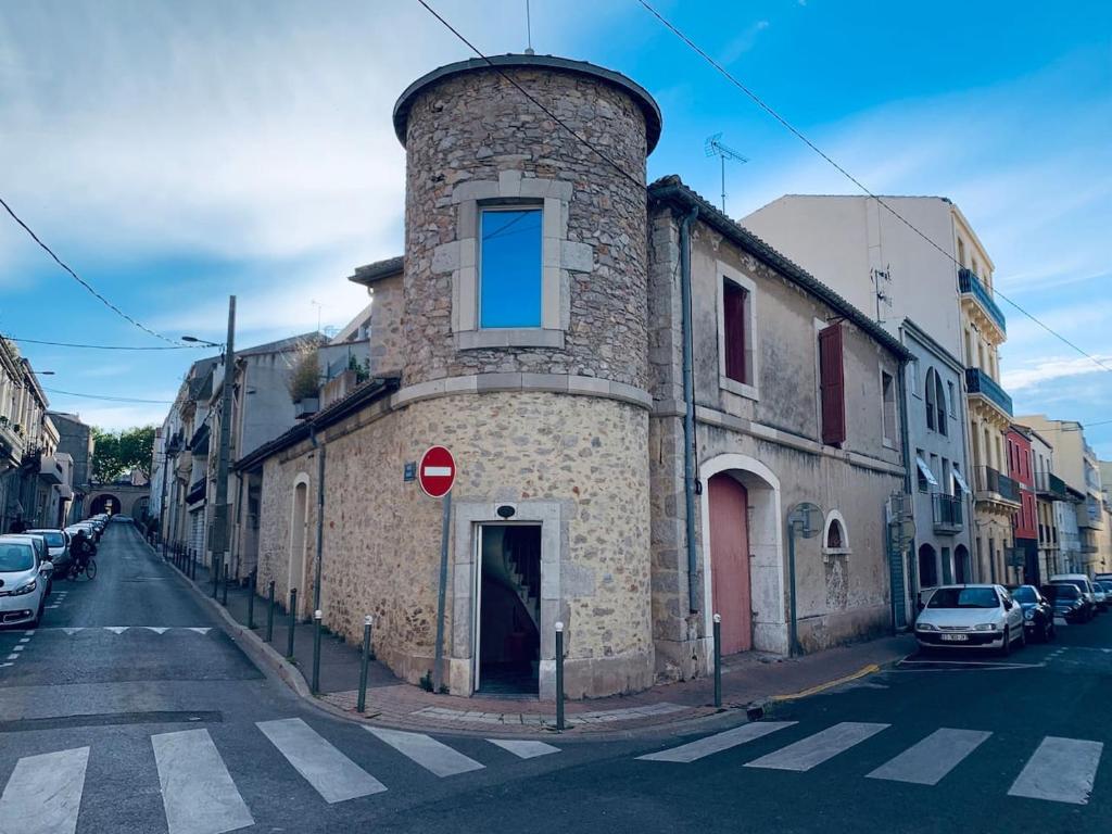 un bâtiment avec une tour sur le côté d'une rue dans l'établissement Maison de maitre, coeur de ville., à Sète