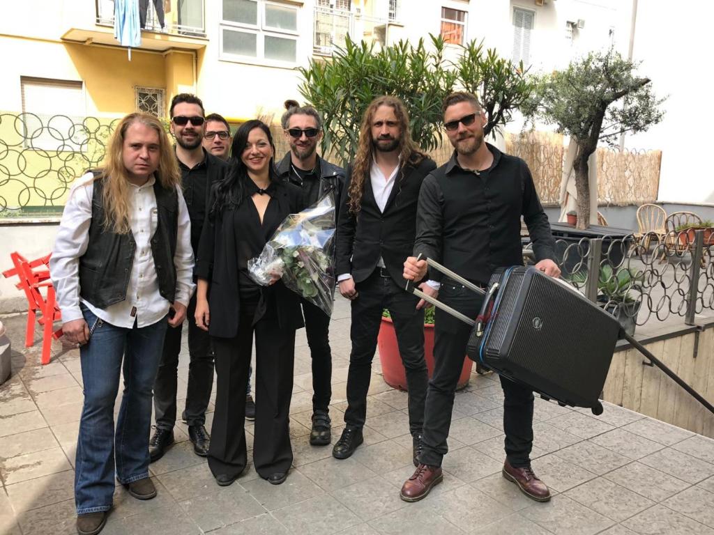 un gruppo di persone che posano per una foto con una valigia di Ostello Old Milano a Milano