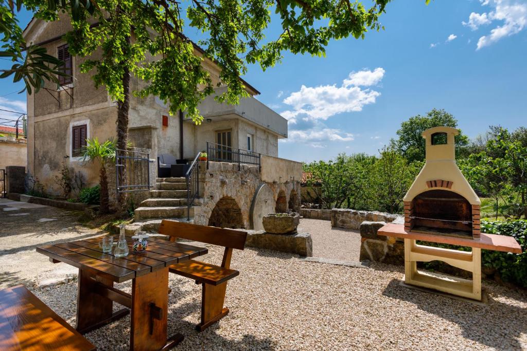 a patio with a table and a pizza oven at Kuća za odmor "Na Paltu" in Risika