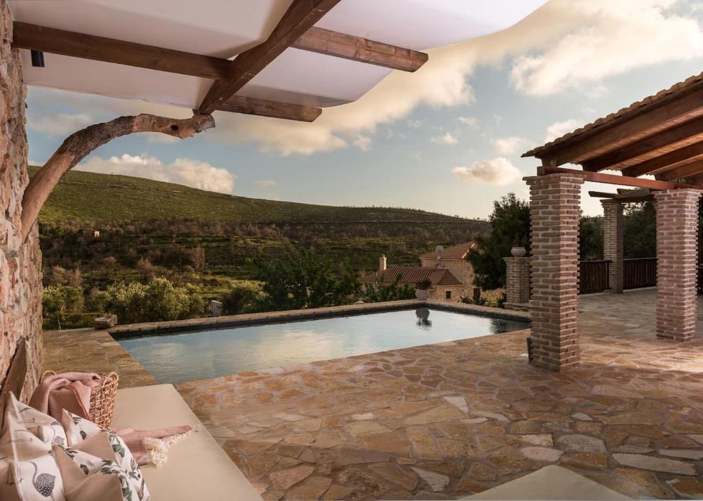 a swimming pool in a backyard with a stone patio at Villa Margarita in Anafonítria