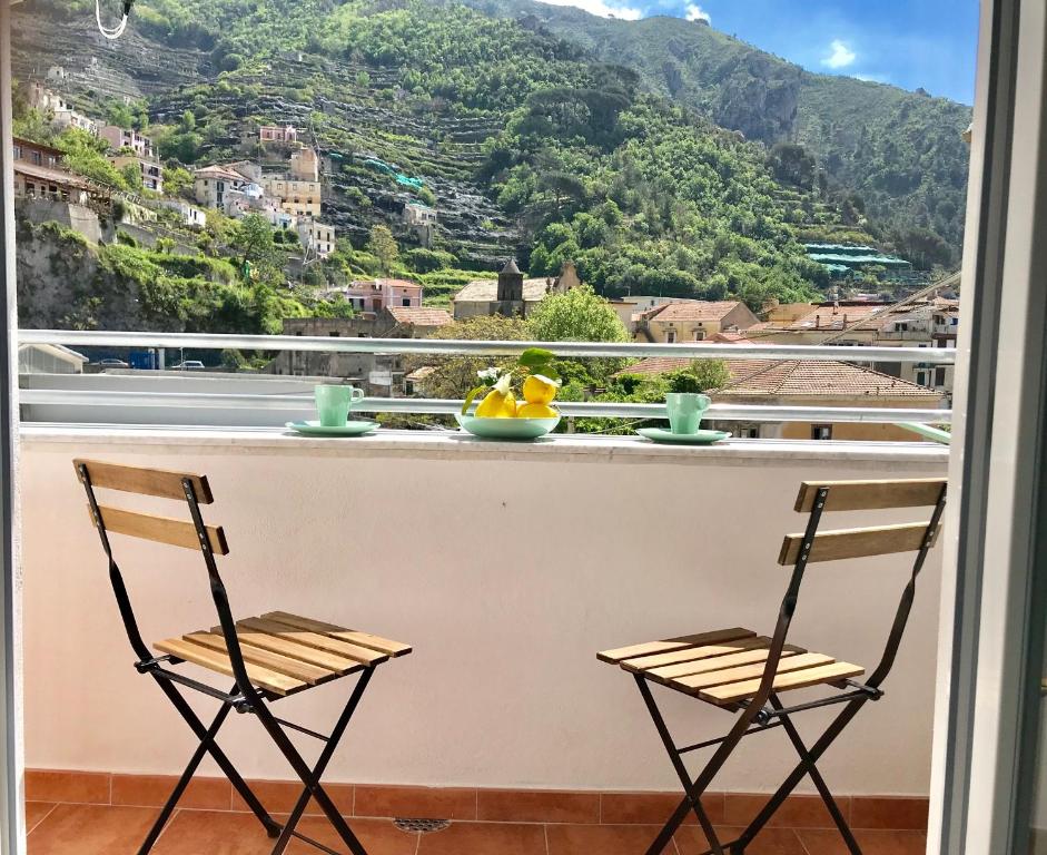 2 sedie su un balcone con vista sulle montagne di Trifoglio Apartment a Maiori