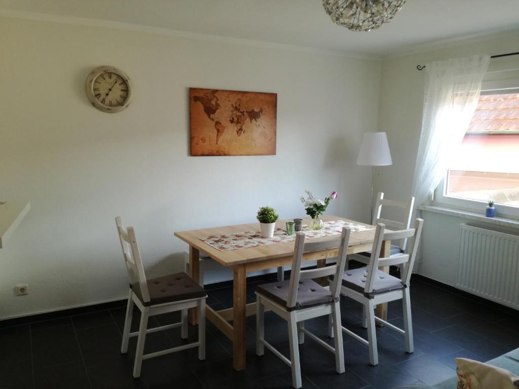 einen Esstisch mit Stühlen und eine Uhr an der Wand in der Unterkunft Bella Casa in Laufenburg