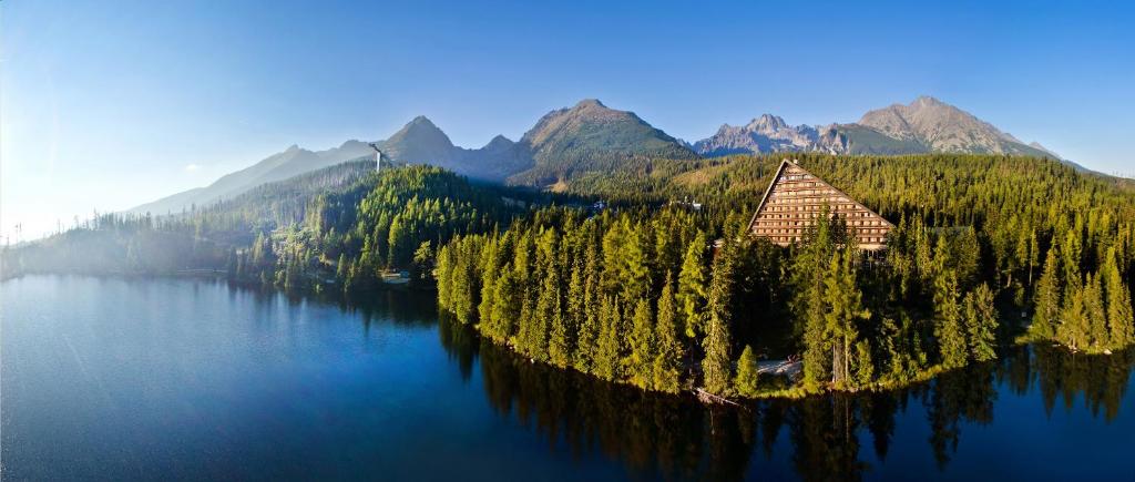 a house on an island in the middle of a lake at Hotel Patria in Vysoke Tatry - Strbske Pleso