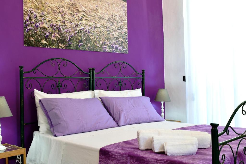 ガラトーネにあるResidenza Santa Lucia B&Bの紫の壁のベッドが備わる紫のベッドルーム1室が備わります。