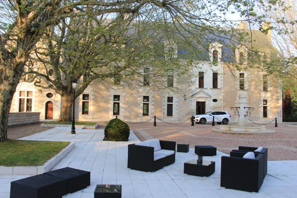 un patio con sofás frente a un edificio en Château de la Menaudière, en Chissay-en-Touraine