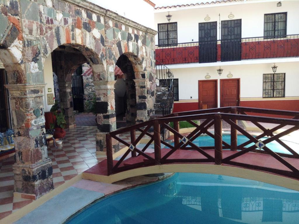 uma ponte sobre uma piscina num edifício em Villa San Francisco Hotel em Taxco de Alarcón