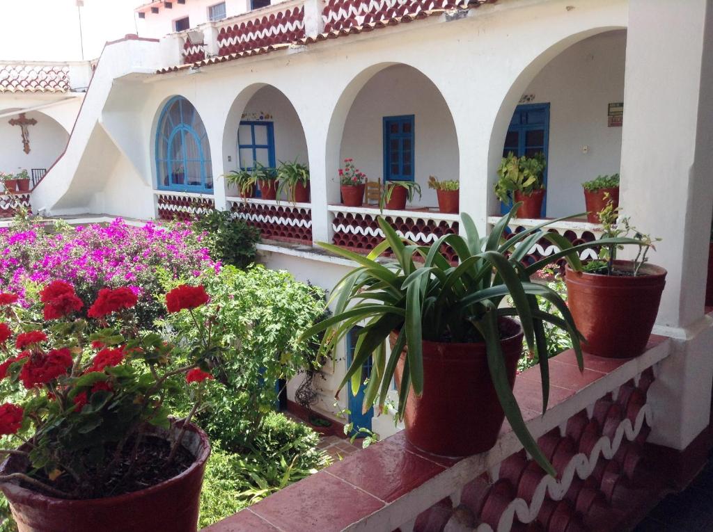 a balcony with potted plants on a building at Hotel Santa Prisca in Taxco de Alarcón