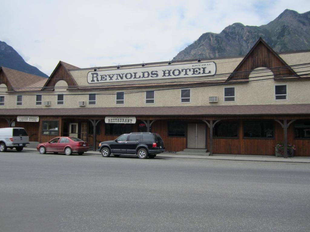 a large hotel with cars parked in front of it at Reynolds Hotel in Lillooet
