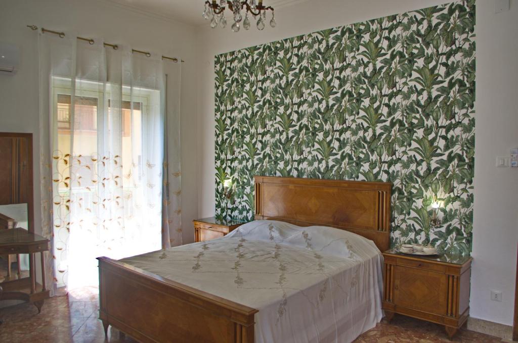 una camera con letto e parete verde e bianca di Olivarooms a Palermo