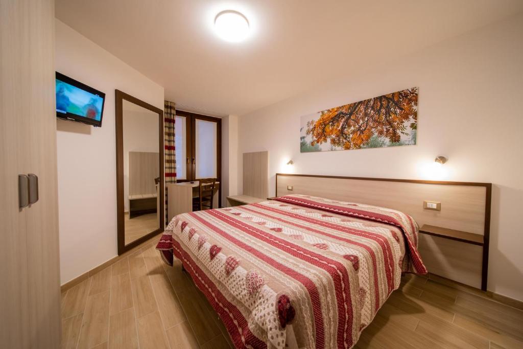 a bedroom with a bed and a tv on a wall at Maison de Rosy Chambres in Aosta